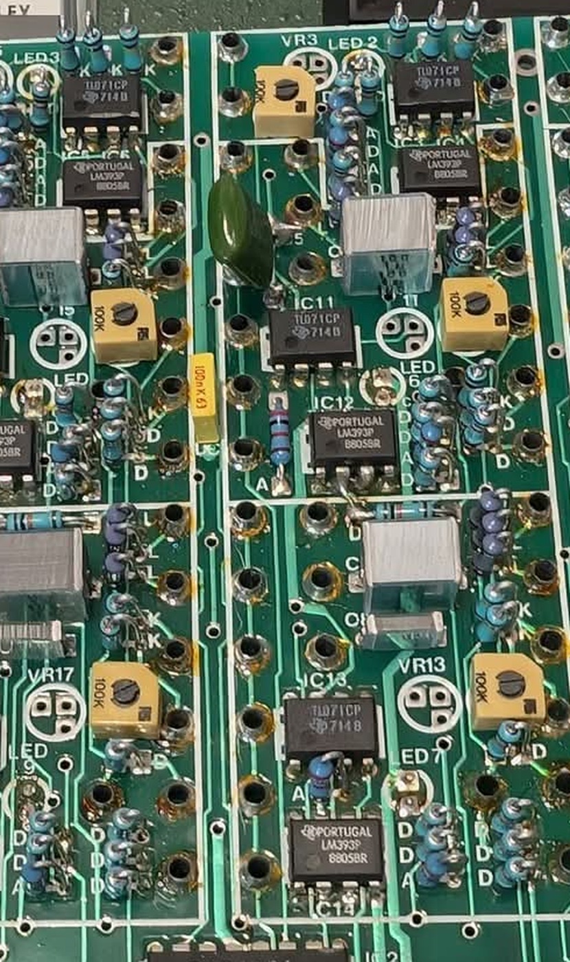 One of the repeated amplifier groups at close range, showing a TL071CP above an LM393P, a yellow 100K trimmer, an indicator LED and a film capacitor.