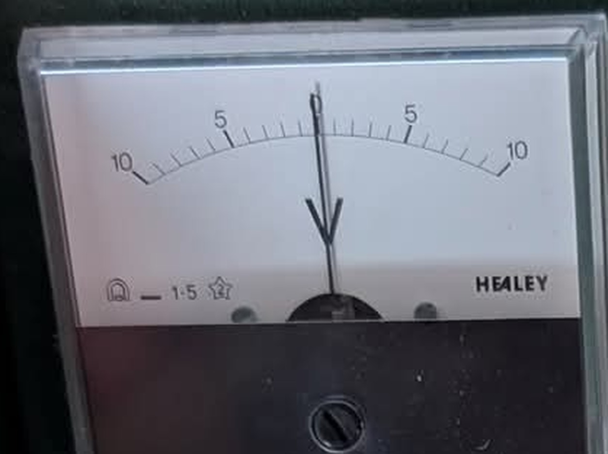 The meter dial: a centre-zero scale reading 10-5-0-5-10 with the maker's name HEALEY at the lower right and class markings at the lower left.
