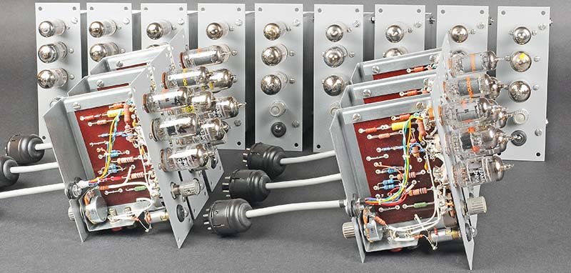 Fifteen ES-201 operational amplifier modules after restoration, showing the phenolic PCBs, tube sockets, and sheet-metal housings