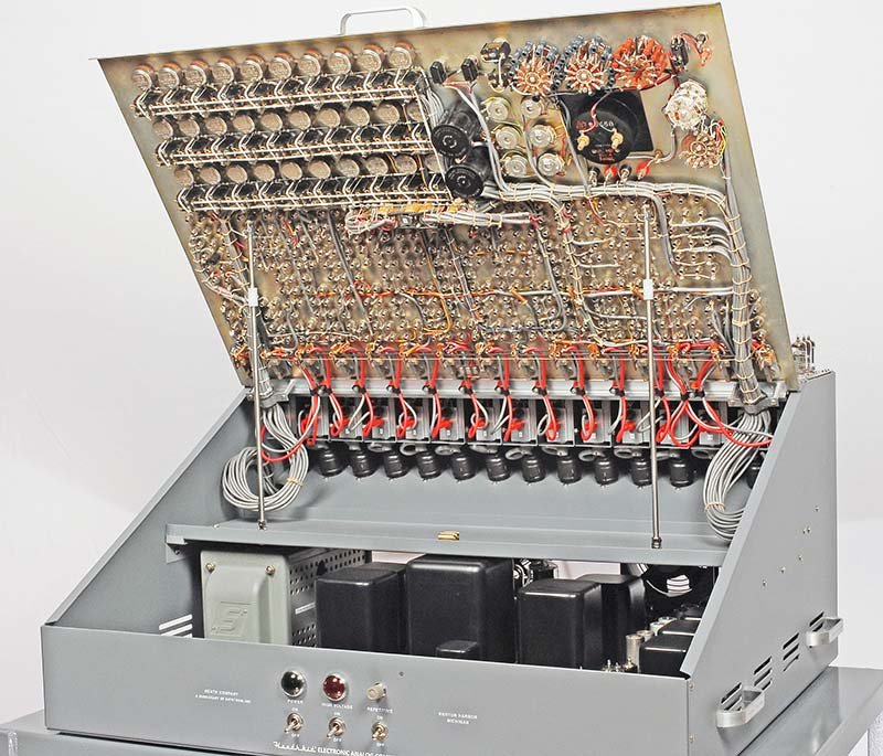 Interior of the ES-400 with the front panel tilted forward, showing the dense wiring harness connecting all 364 front-panel jacks to the sub-assembly connectors behind the panel. The ES-201 modules are visible in their row positions, tubes glowing.